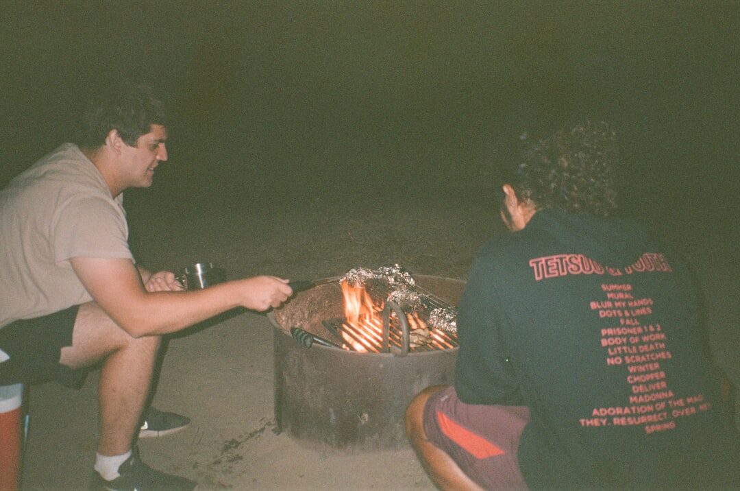 Amigos se divertindo ao redor de uma fogueira contando histórias